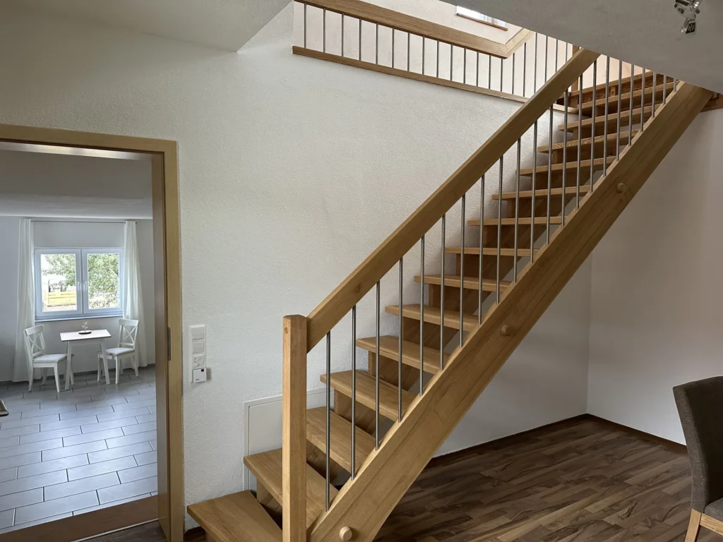 Offene Holztreppe zwischen den beiden Wohnebenen der Ferienwohnung Balzheim