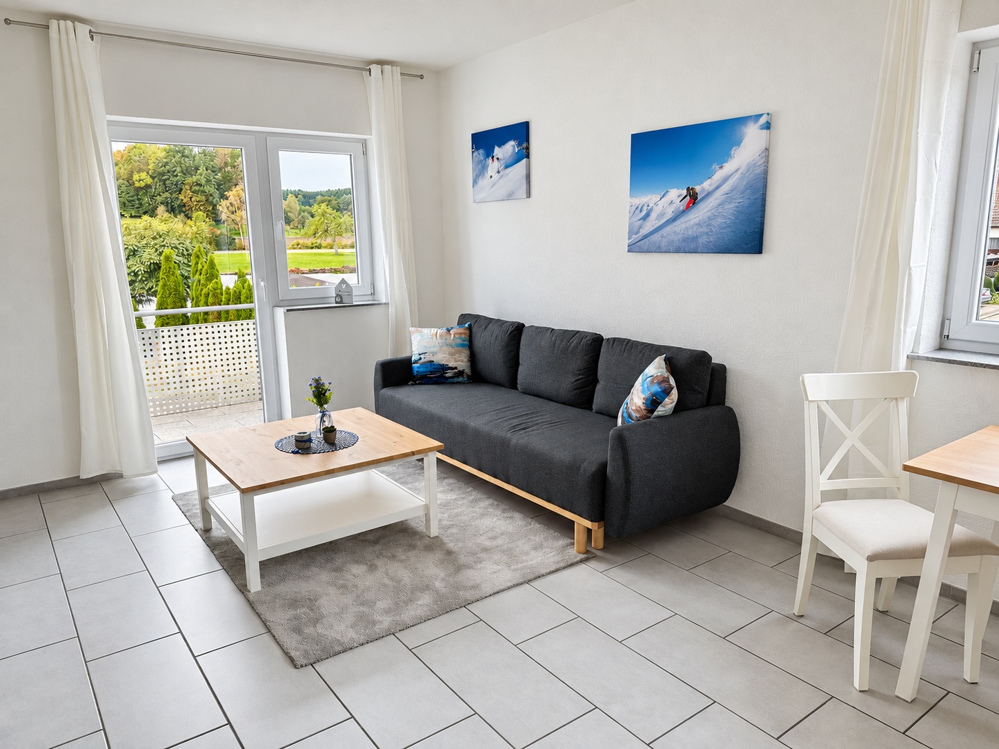 Wohnzimmer der Ferienwohnung Balzheim mit Sofa und Zugang zum Balkon
