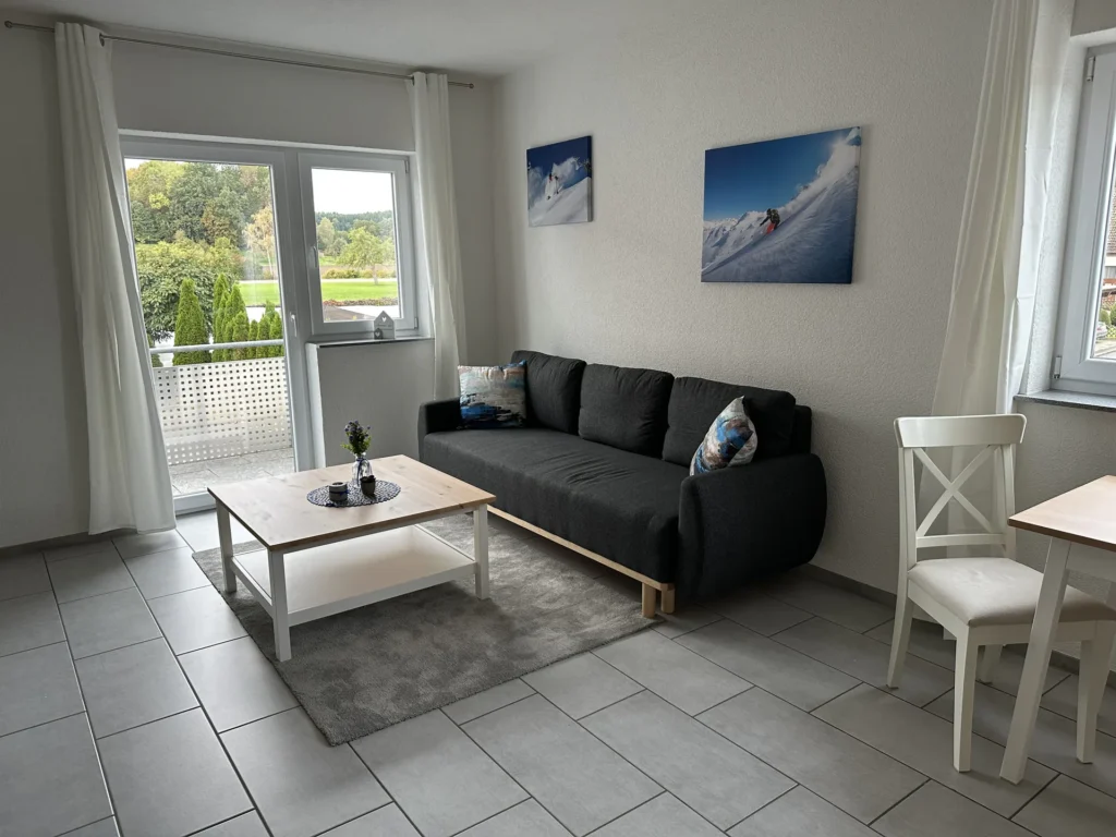 Heller Wohnbereich mit Schlafsofa und Zugang zum Balkon in Balzheim