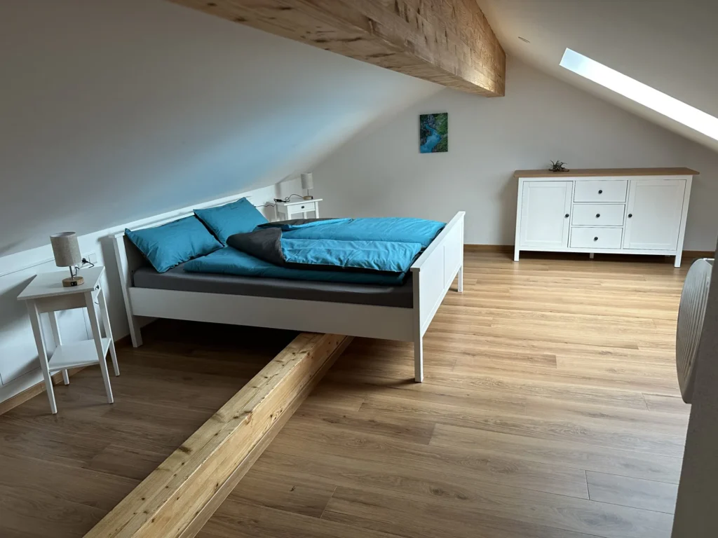 Zweites Schlafzimmer mit Queensize-Bett im Dachgeschoss der Ferienwohnung Balzheim
