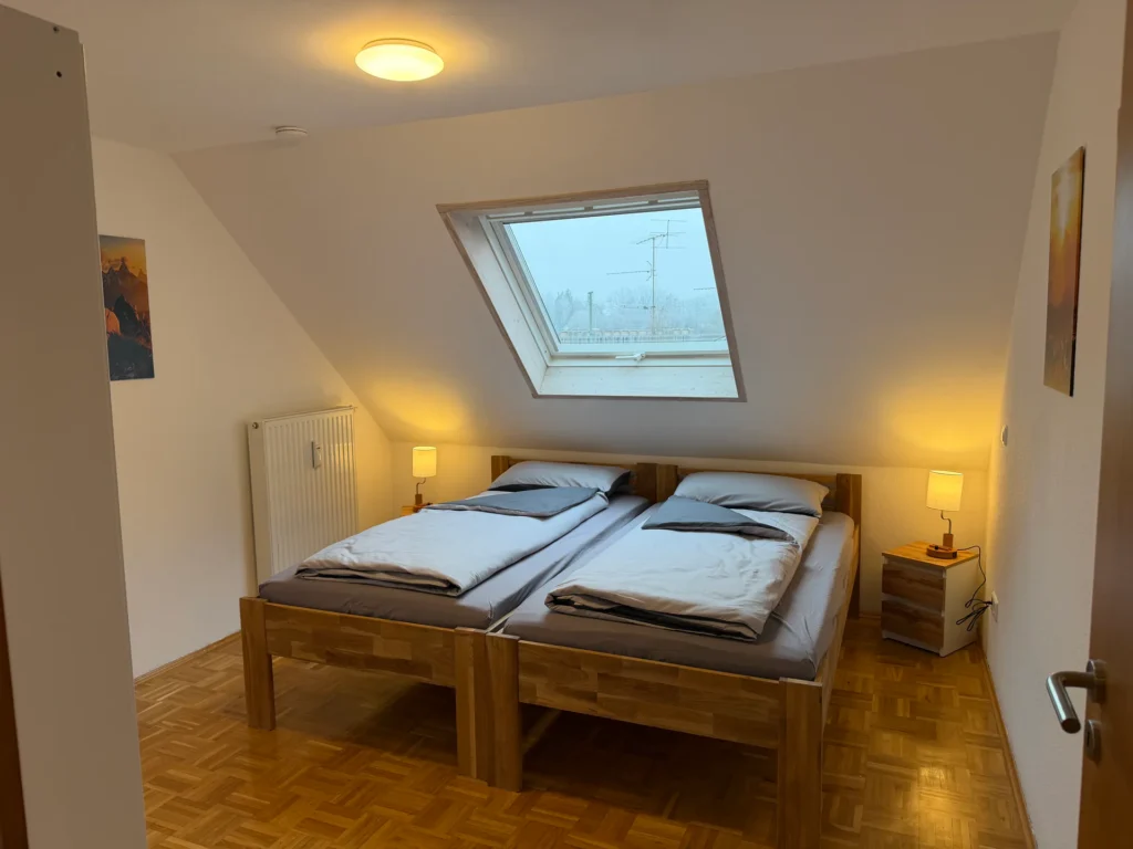 Schlafzimmer unter der Dachschräge mit zwei vorbereiteten Einzelbetten in Memmingen